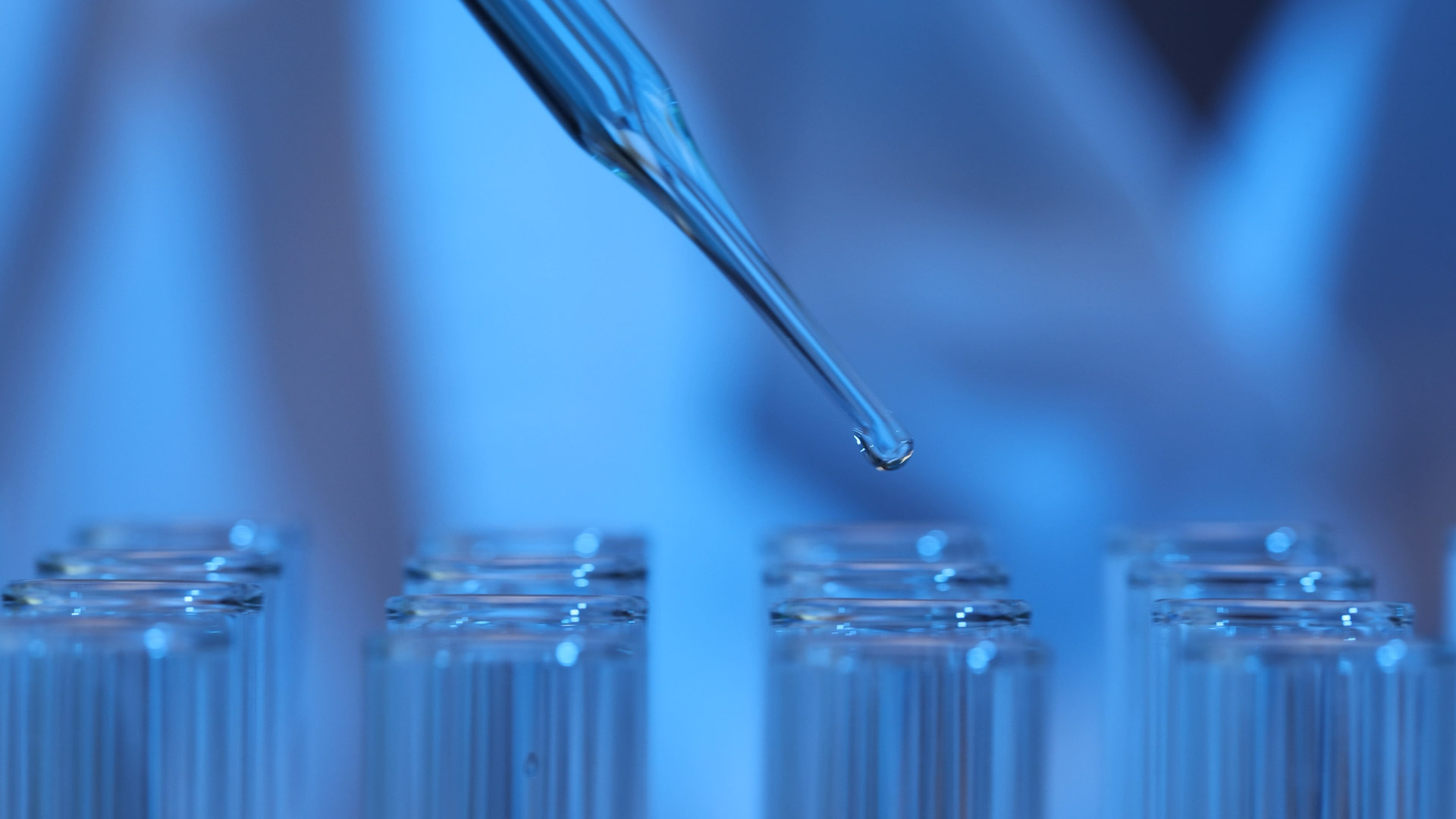 Macro of a pipette and test tubes for clinical wellness standards.