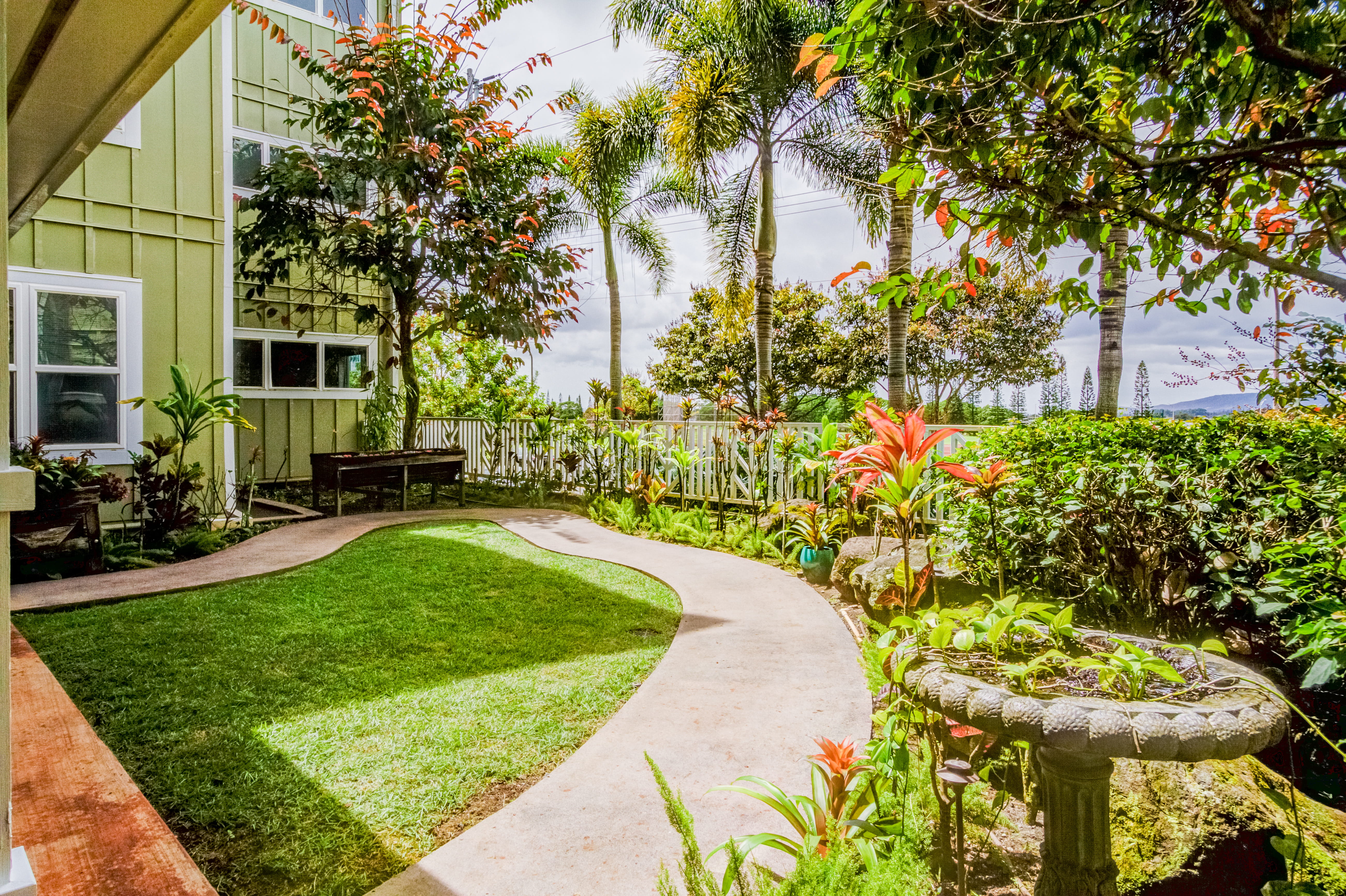 Tropical garden path and birdbath at an assisted living facility with memory care.