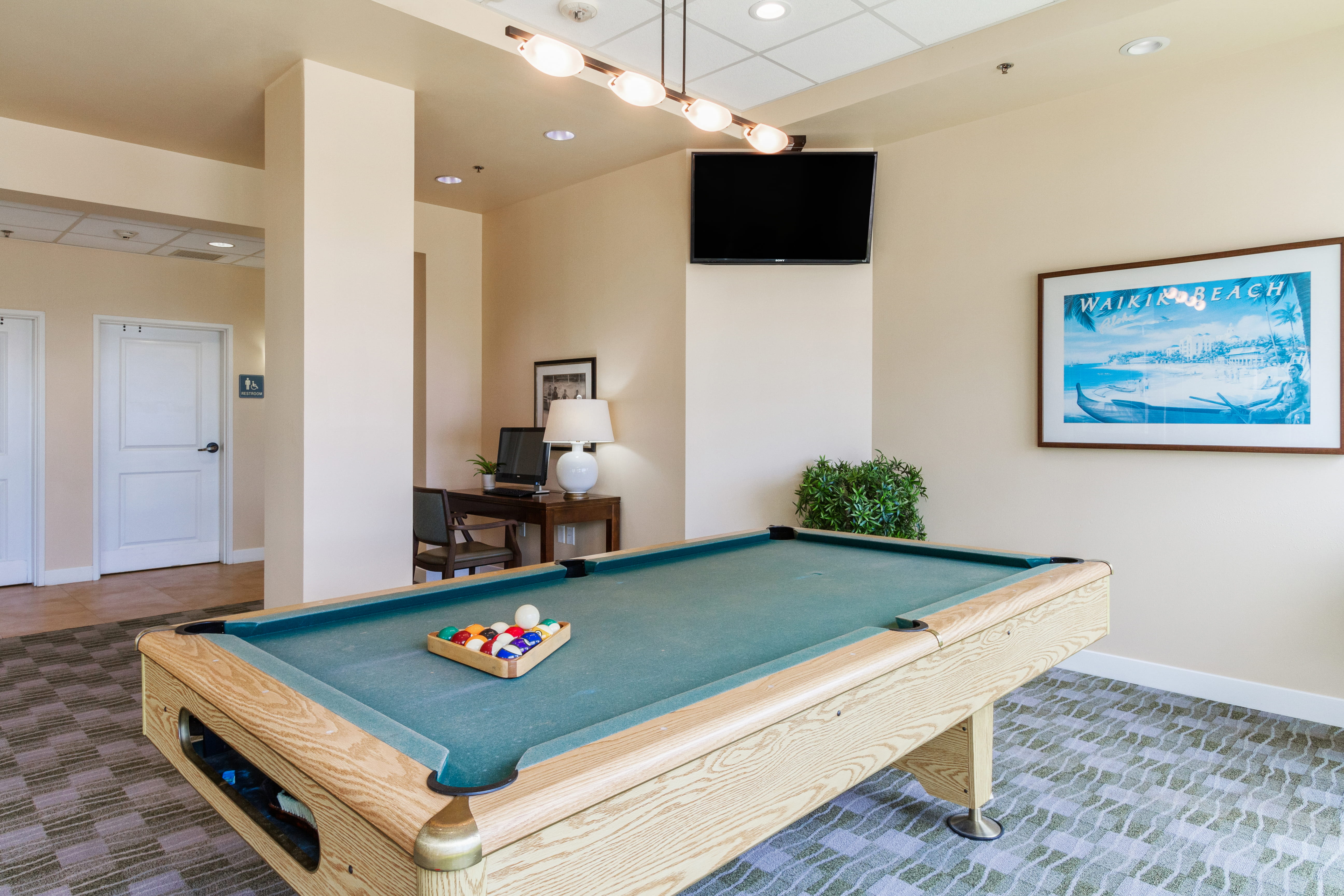 Billiards table and computer station in a recreation room at The Plaza Assisted Living.