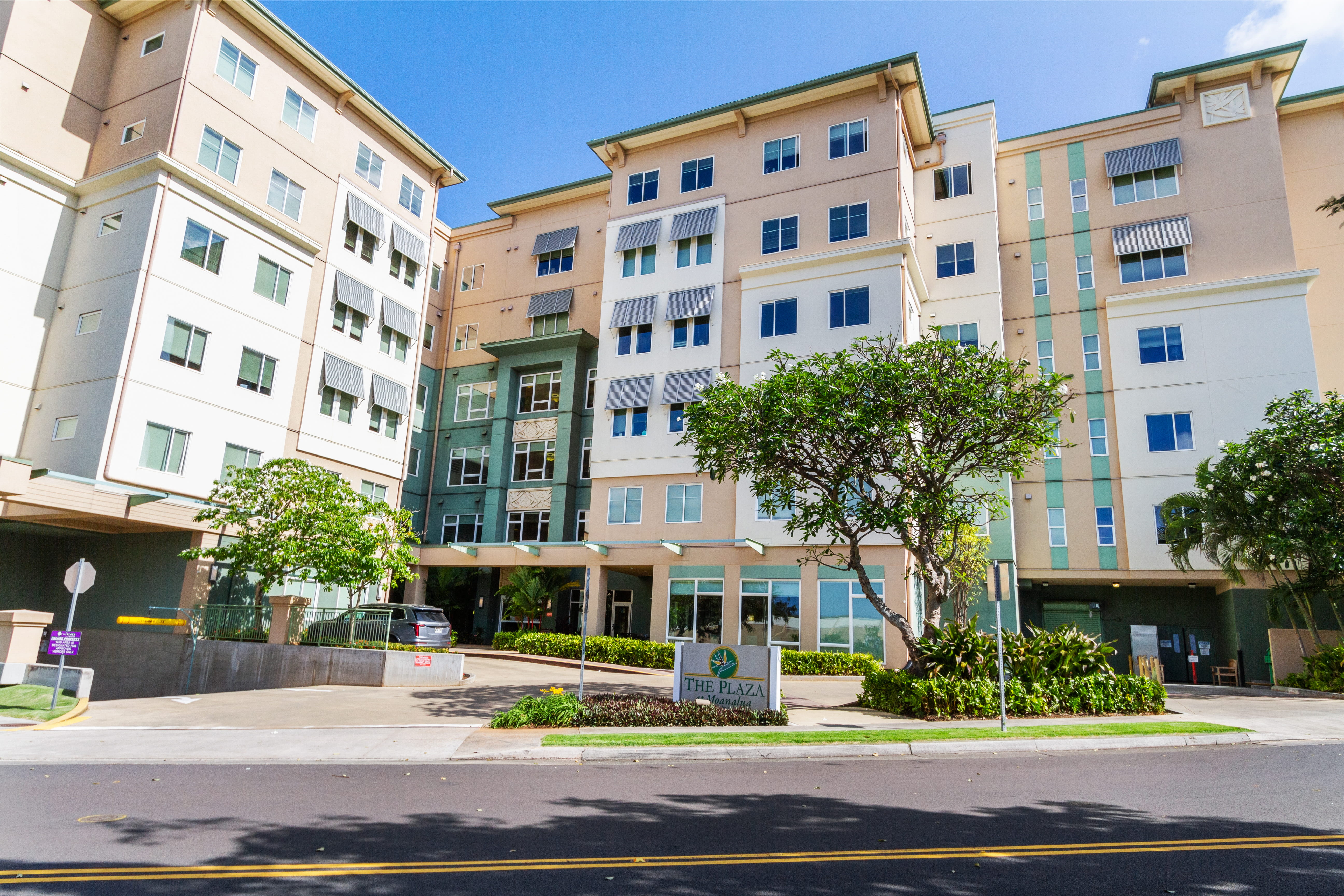 Exterior view of The Plaza Assisted Living Moanalua building and entrance sign.