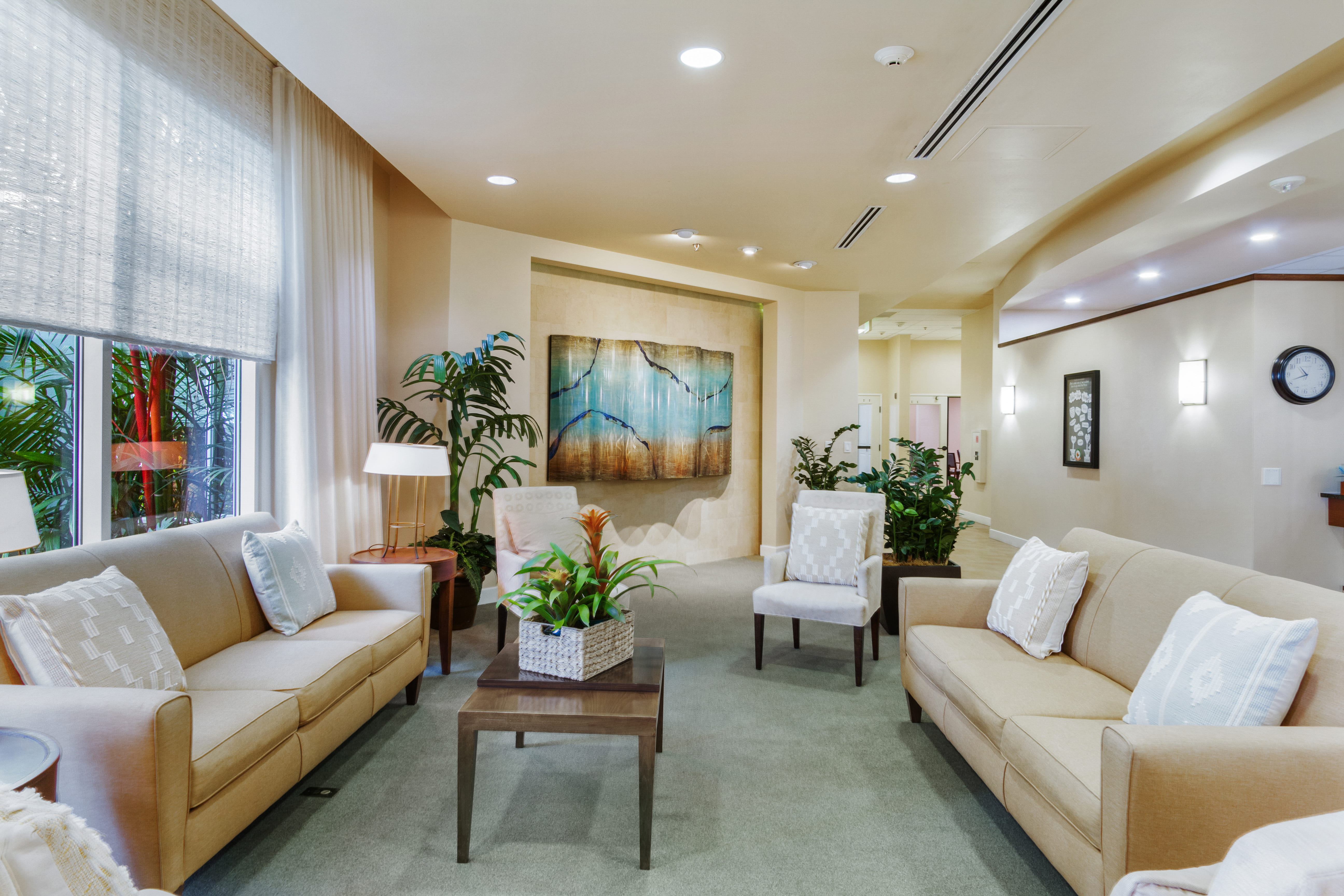 Lobby lounge at The Plaza Assisted Living Moanalua with comfortable sofas and modern decor.
