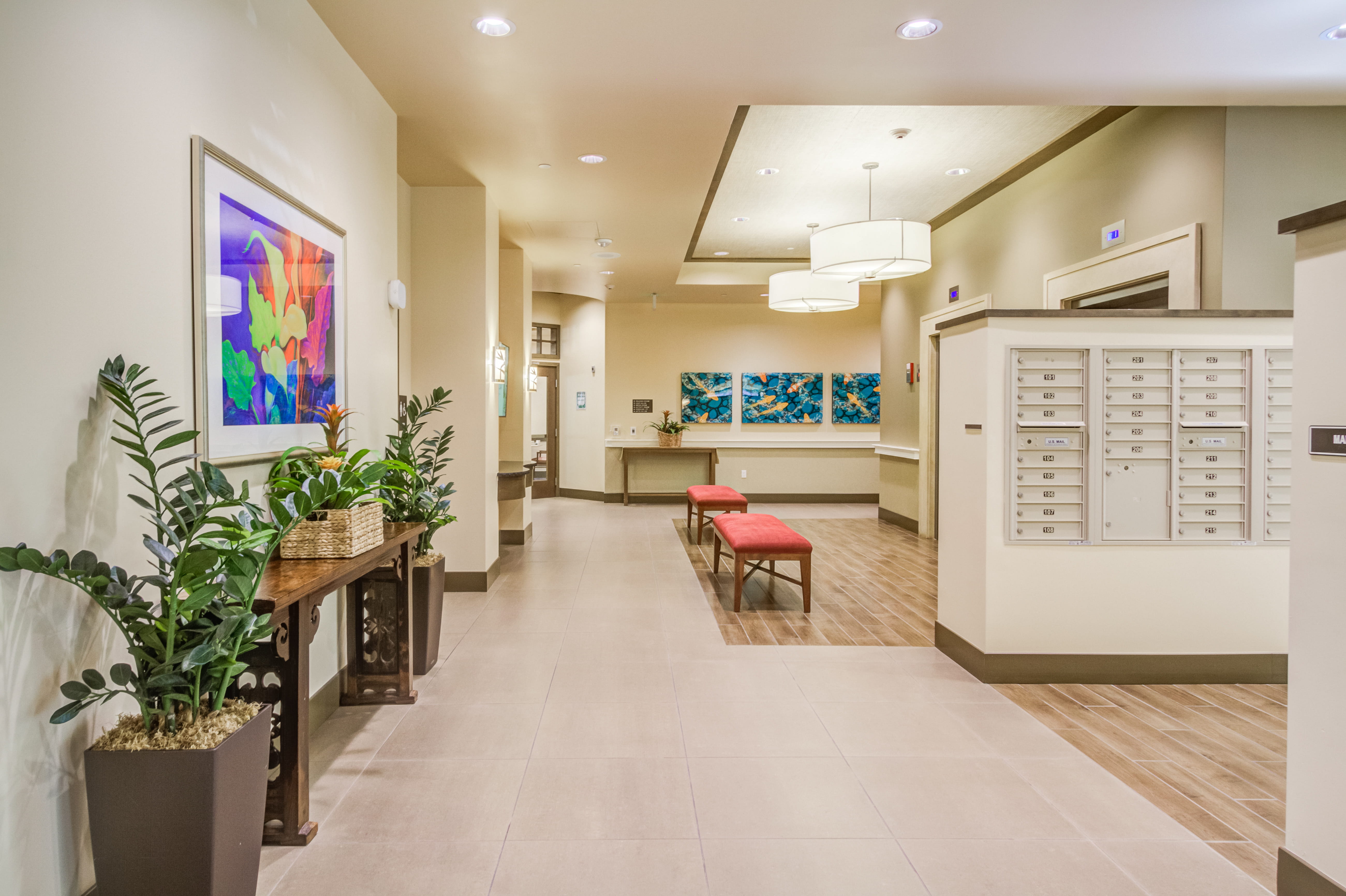 Modern hallway at The Plaza Assisted Living Pearl City with mailboxes and colorful art.