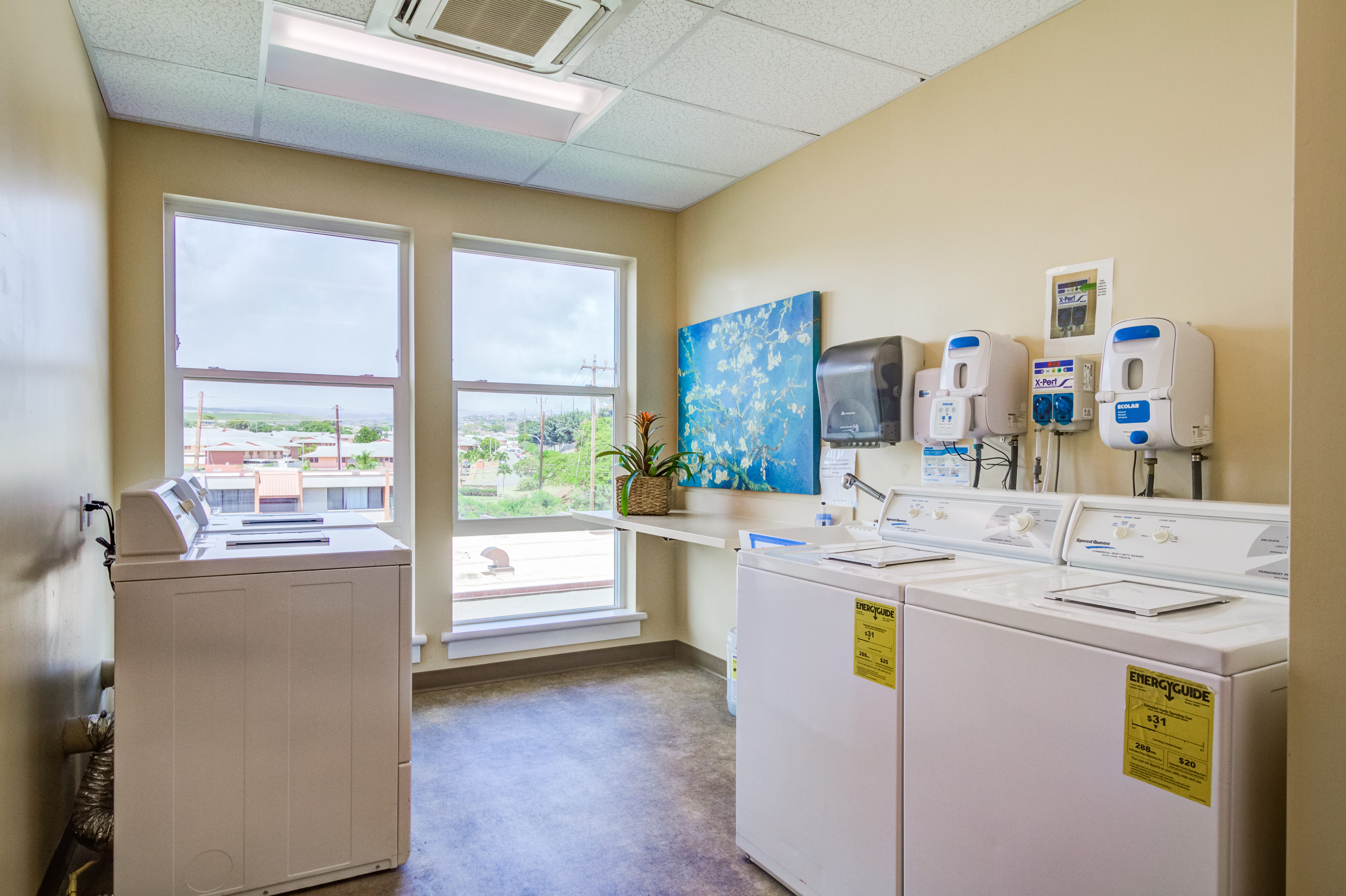 On-site resident laundry room with white washing machines and dryers at The Plaza Assisted Living.