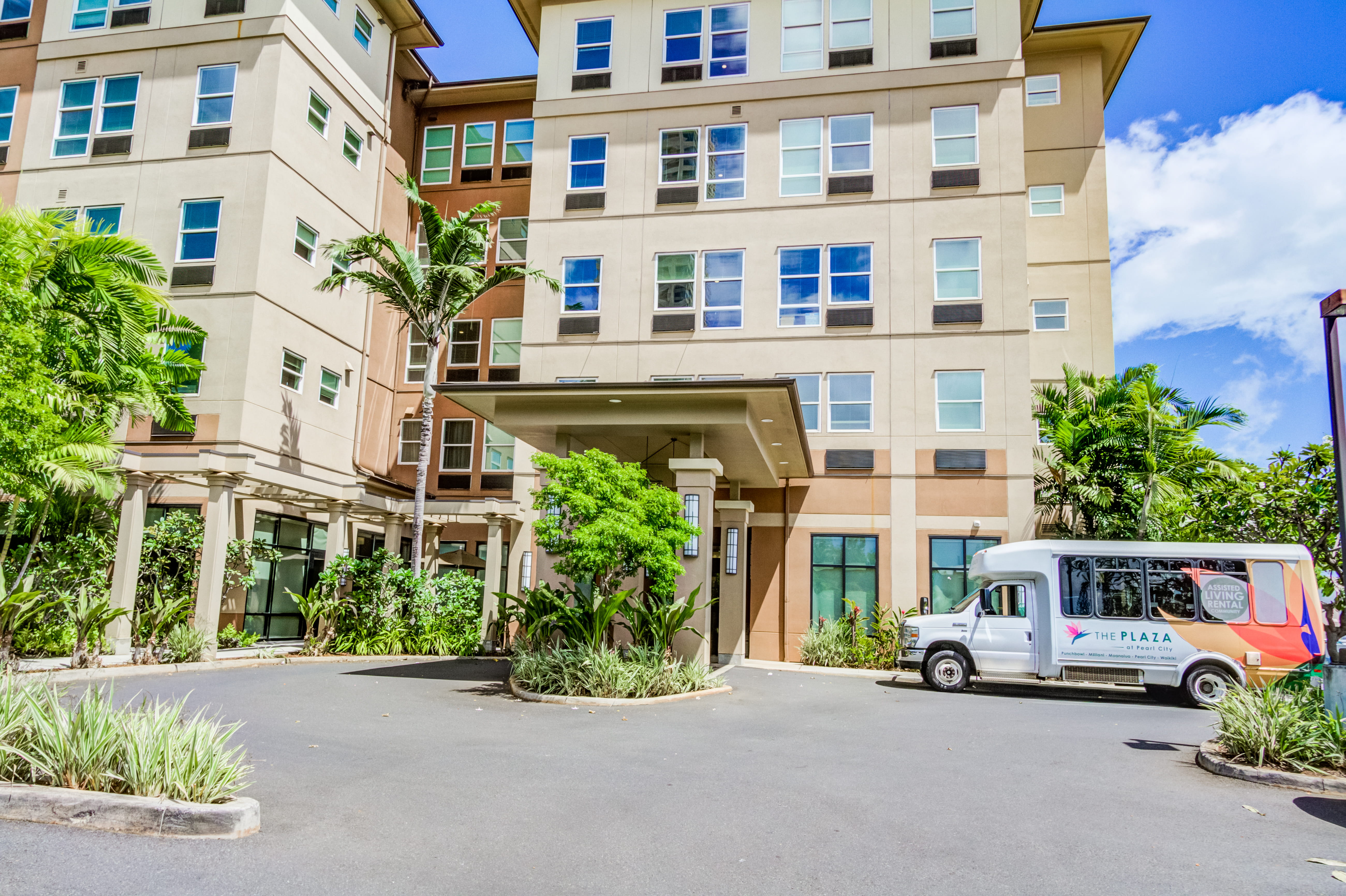 Exterior entrance and resident shuttle bus at The Plaza Assisted Living Pearl City.