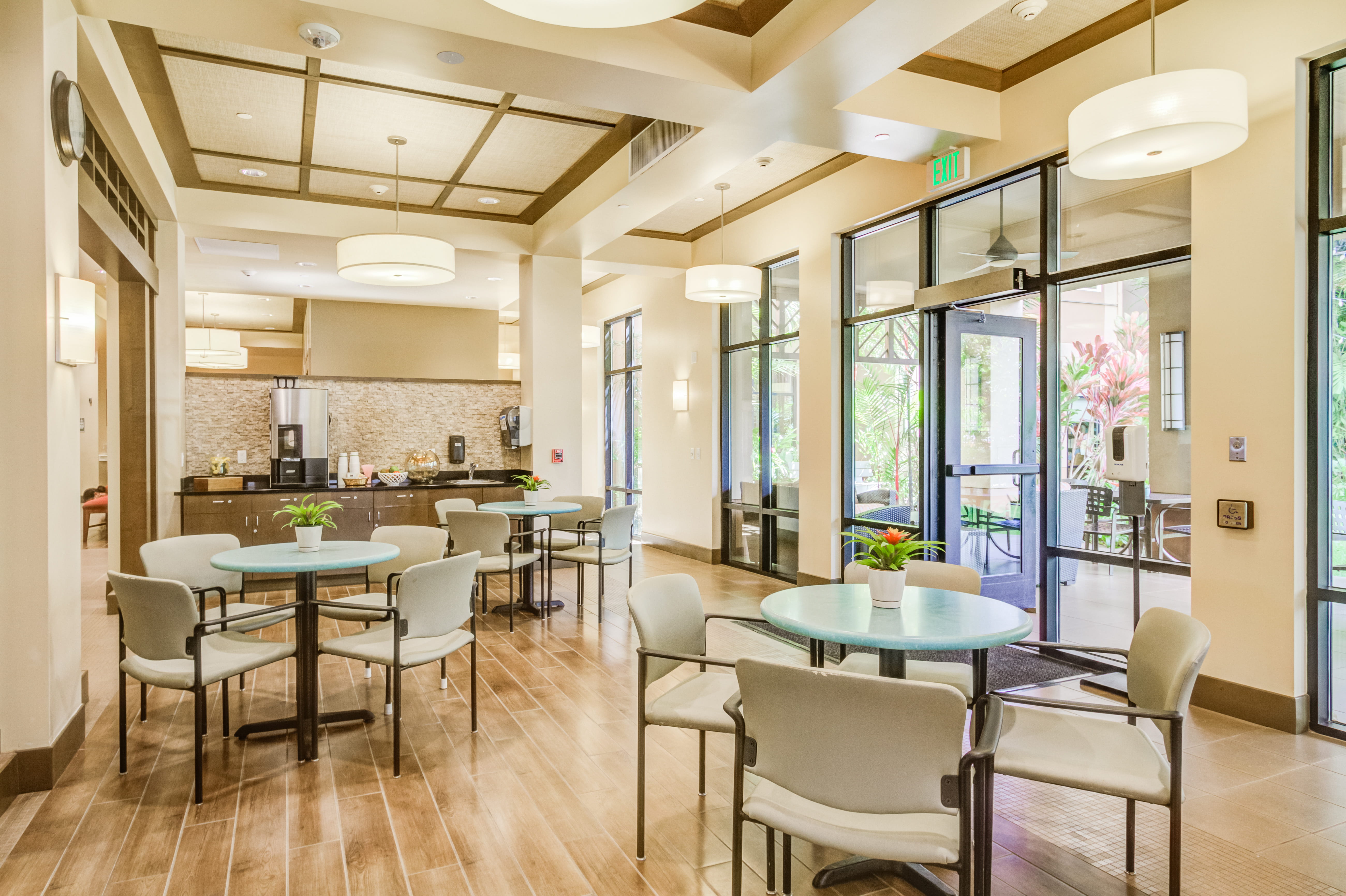 Bistro area at The Plaza Assisted Living Pearl City with round tables and chairs.