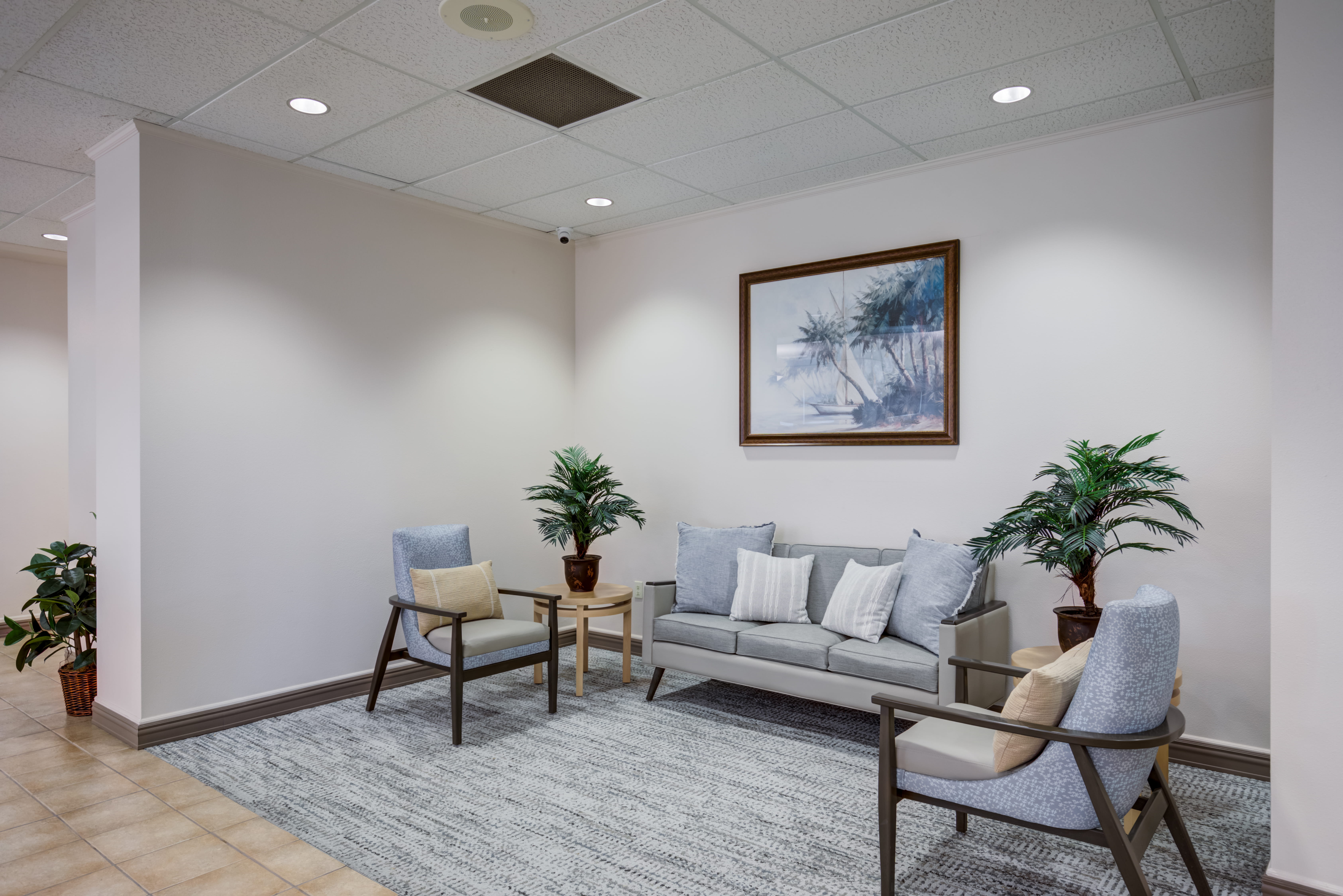 Cozy seating area with a sofa and armchairs at a local senior living facility.