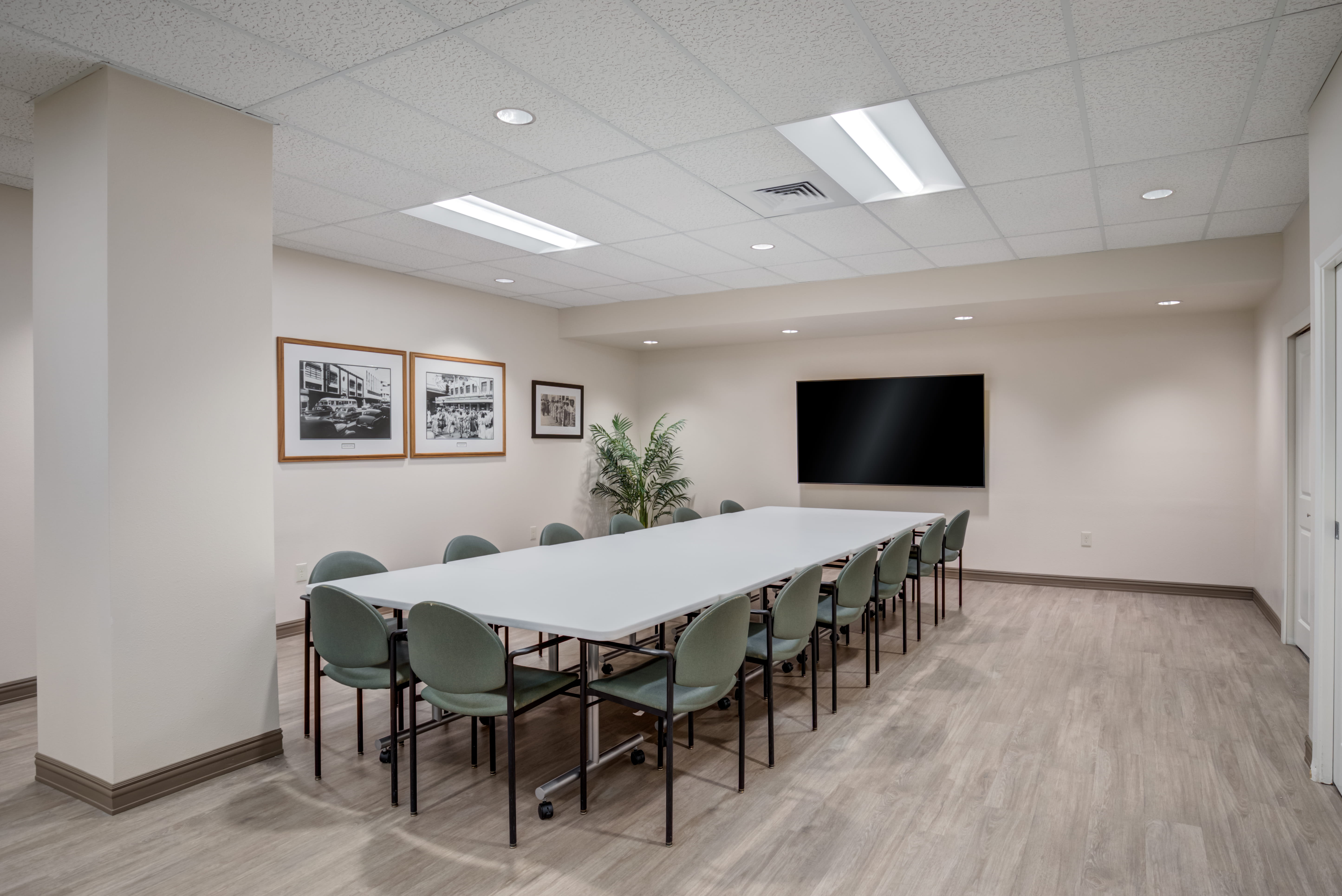 Large meeting room with a long white table and TV at plaza assisted living.