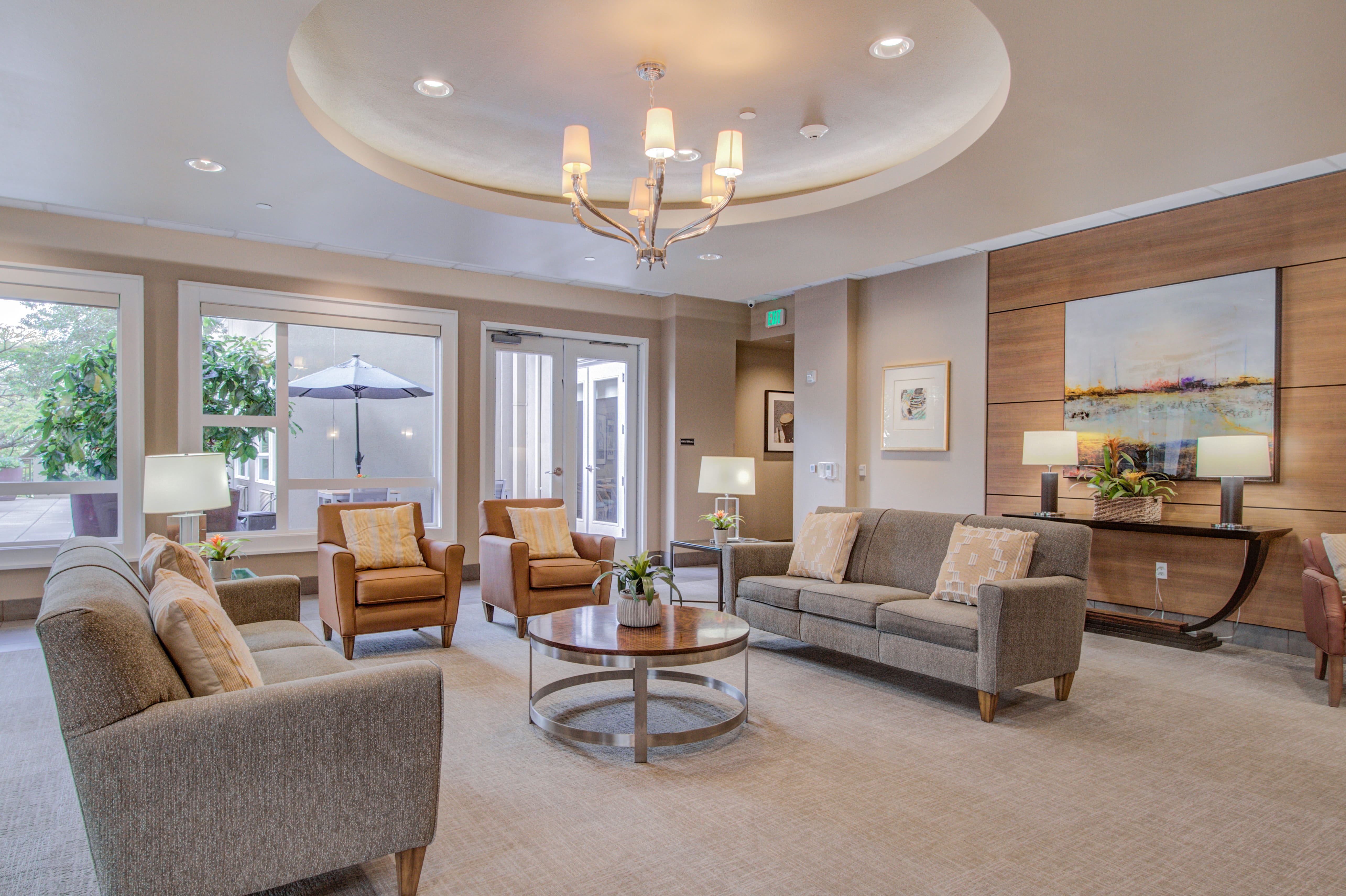 Grand lobby lounge with tan sofas and a large circular chandelier.