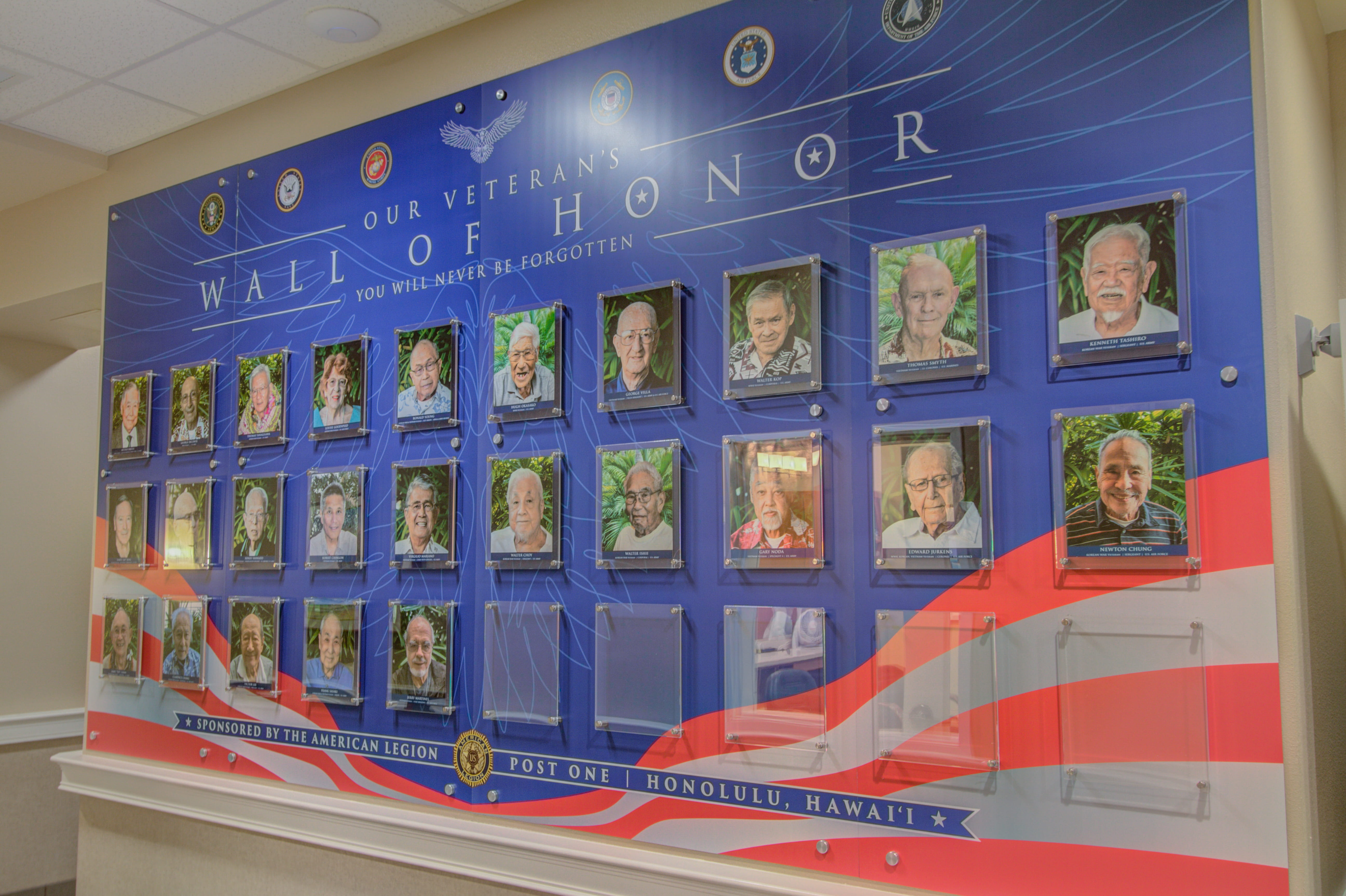 Veteran's Wall of Honor memorial with resident portraits at The Plaza Assisted Living.