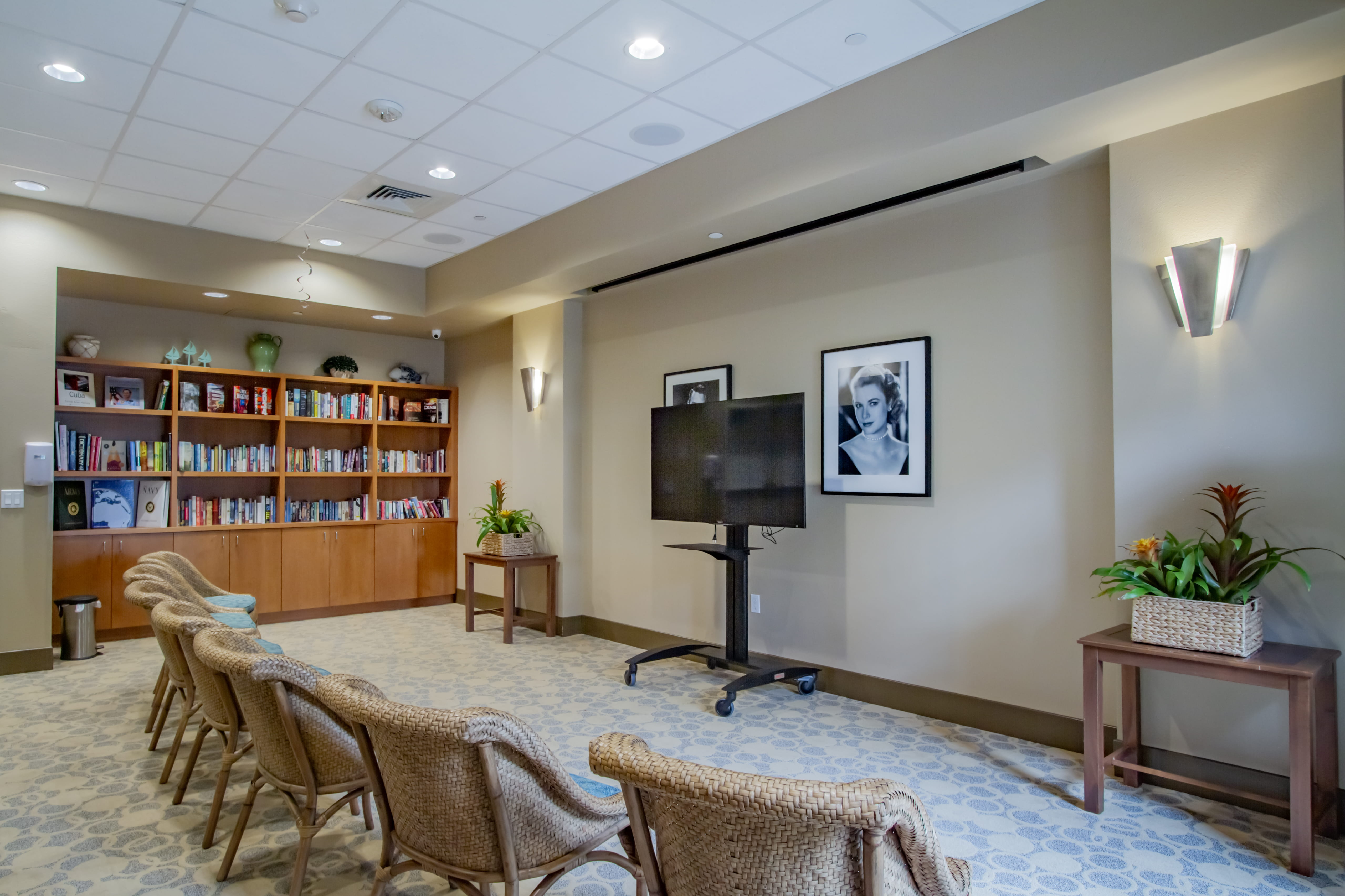 Multipurpose activity room with wicker seating and a large TV at Waikiki.