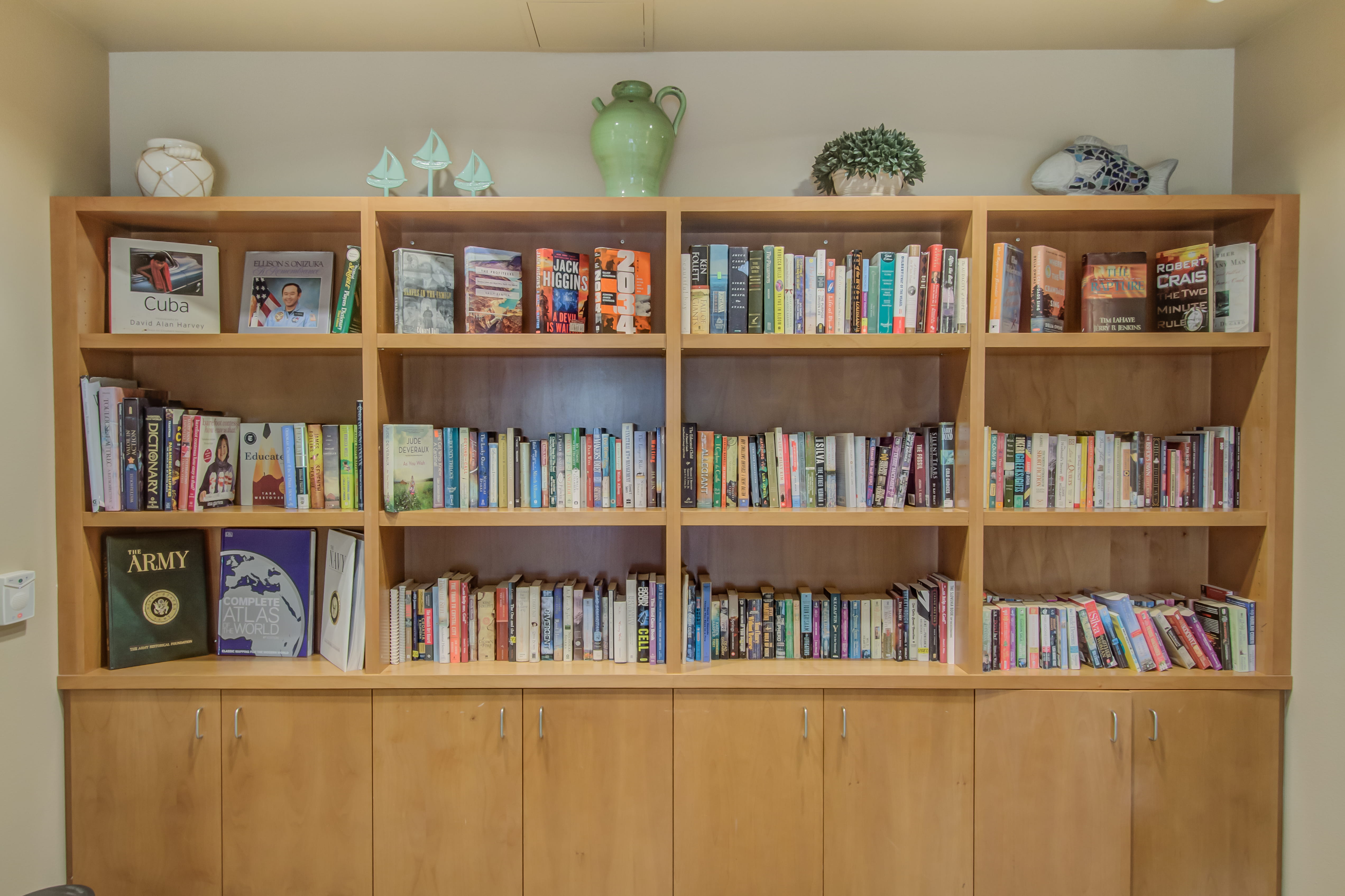 Stocked wooden bookshelves with books and decor at a plaza assisted living community.