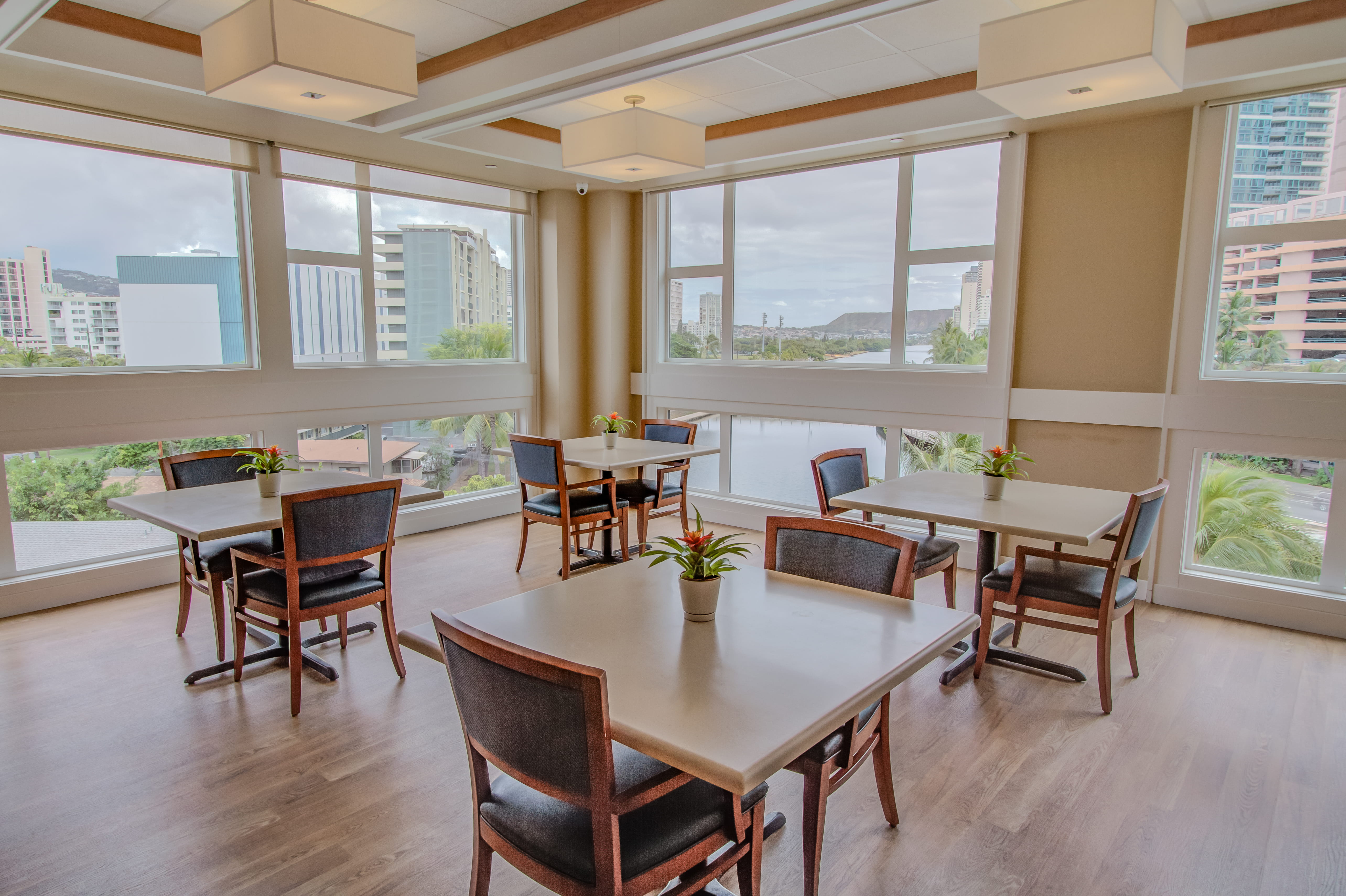Dining area with large windows overlooking Waikiki at The Plaza Assisted Living.