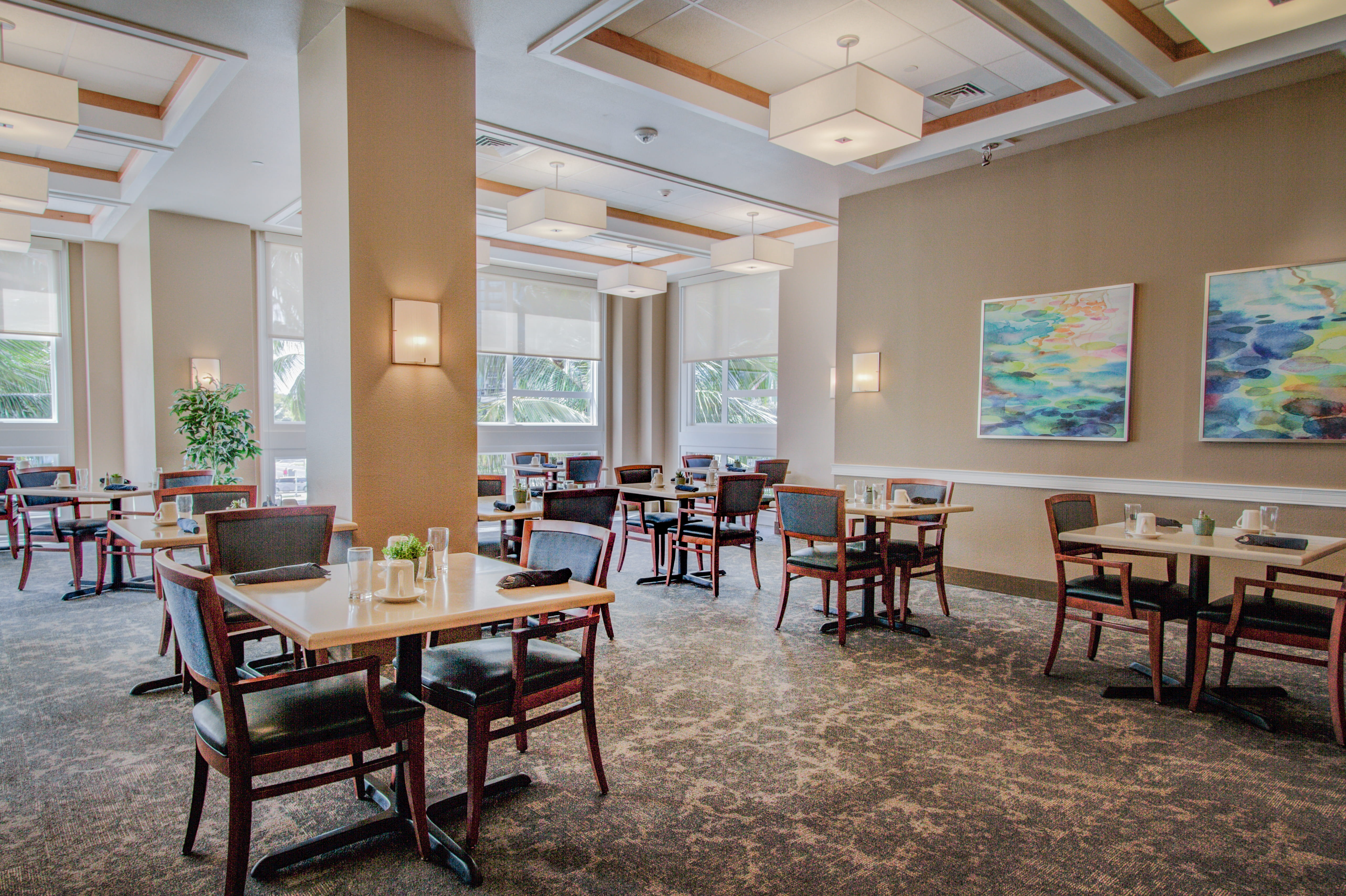 Modern dining area with colorful abstract art and bright lighting.