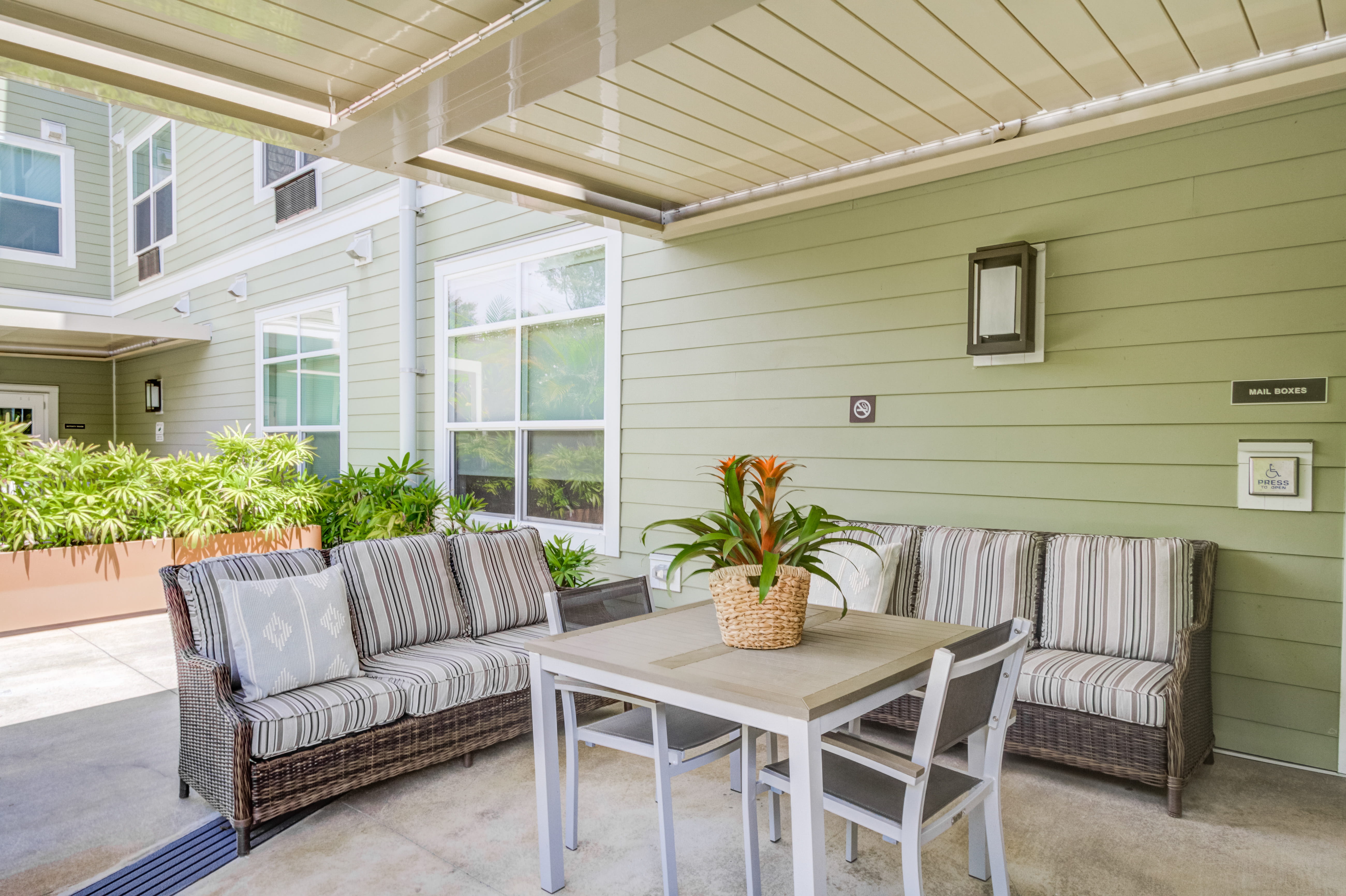 Outdoor patio with comfortable wicker seating at The Plaza Assisted Living.