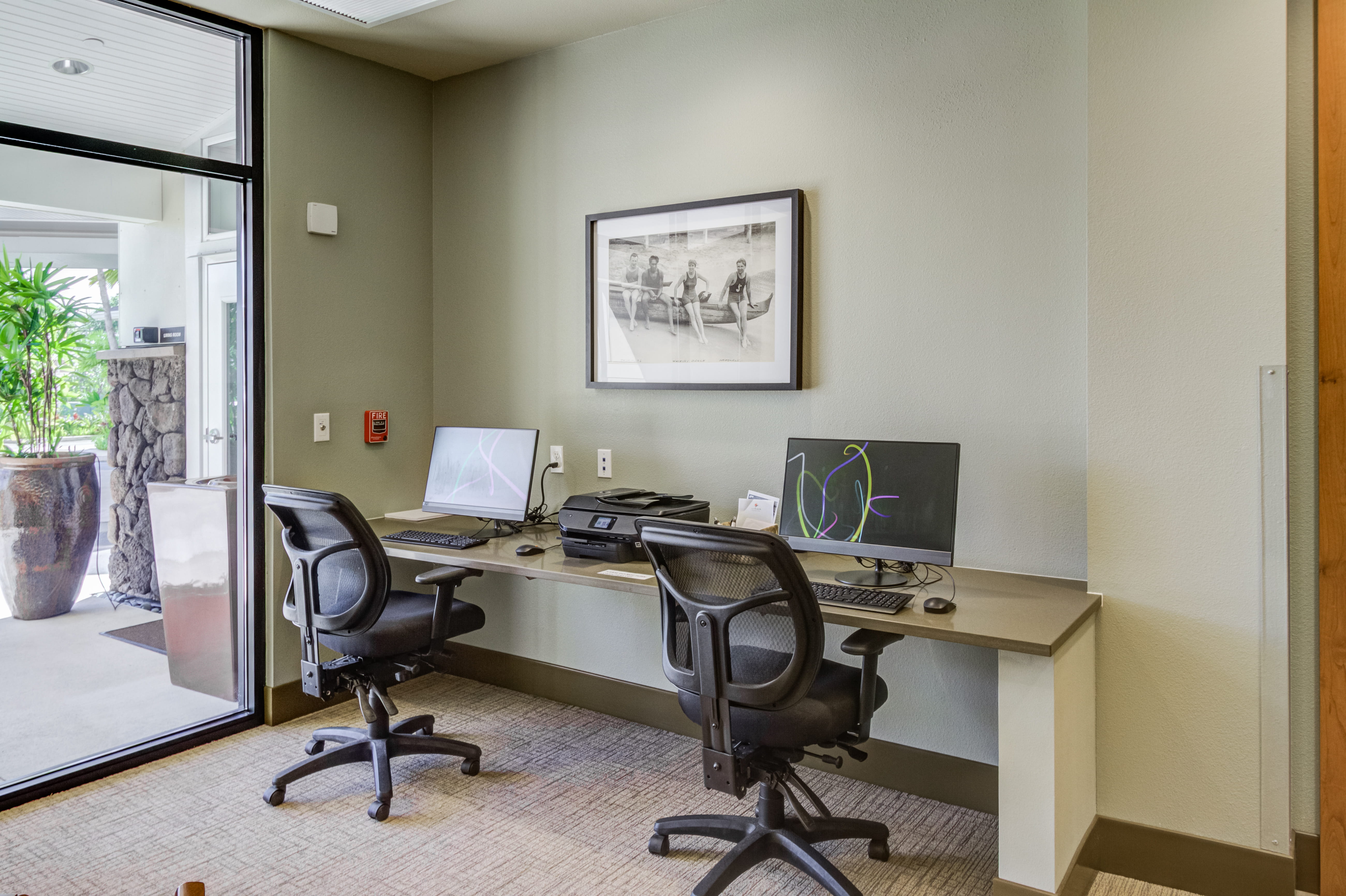 Resident computer workstation with two monitors and a printer.